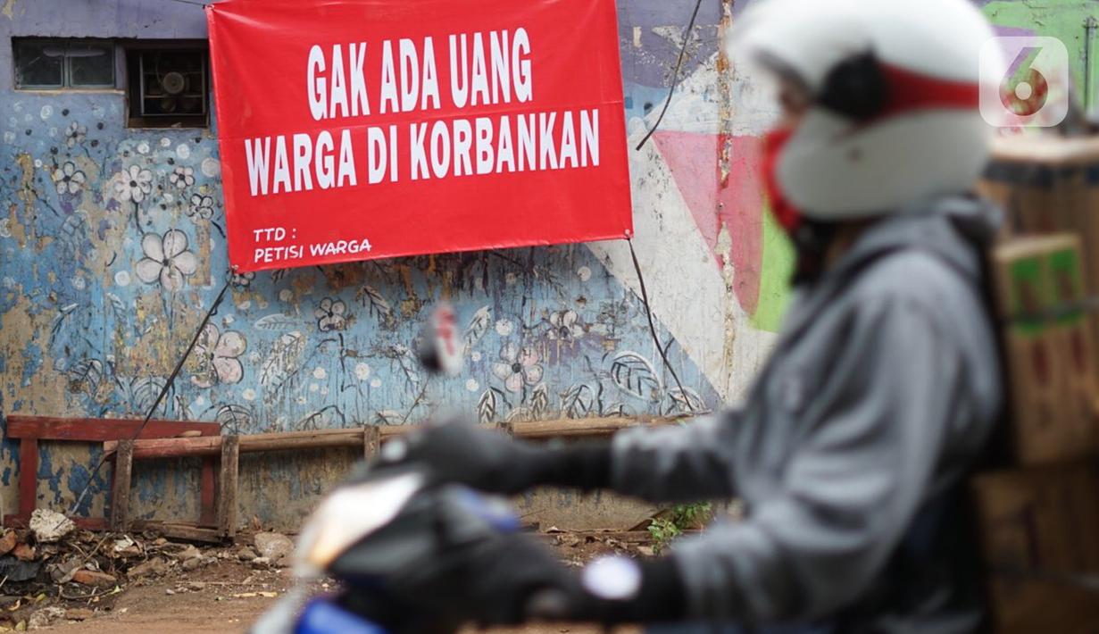 Pengendara motor melintas di depan poster protes warga terhadap pembangunan flyover di kawasan Tanjung Barat, Jakarta, Rabu (15/7/2020). Dalam poster protes tersebut, warga menuntut agar pembayaran pelunasan pembebasan lahan segera diselesaikan secara serentak. (Liputan6.com/Immanuel Antonius)