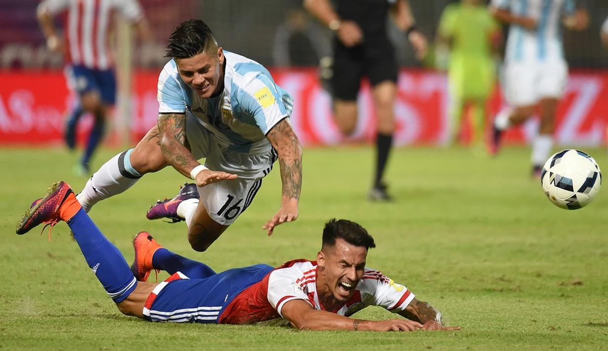 Pemain Argentina, Marcos Rojo, melanggar pemain Paraguay, Hernan Perez, dalam laga Kualifikasi Piala Dunia 2018 zona Amerika Selatan, di Stadion Mario Kempes, Cordoba, Rabu (12/10/2016) pagi WIB. (AFP/Eitan Abramovich)