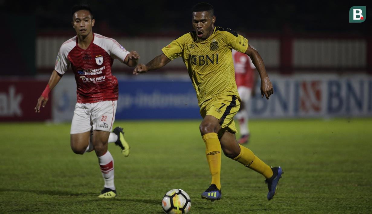 Gelandang Bhayangkara FC, Vendry Mofu, menghindari kejaran gelandang Persipura, Muhammad Tahir, pada laga Liga 1 Indonesia di Stadion PTIK, Jakarta, Senin (18/11). Bhayangkara menang 2-0 atas Persipura. (Bola.com/Vitalis Yogi Trisna)