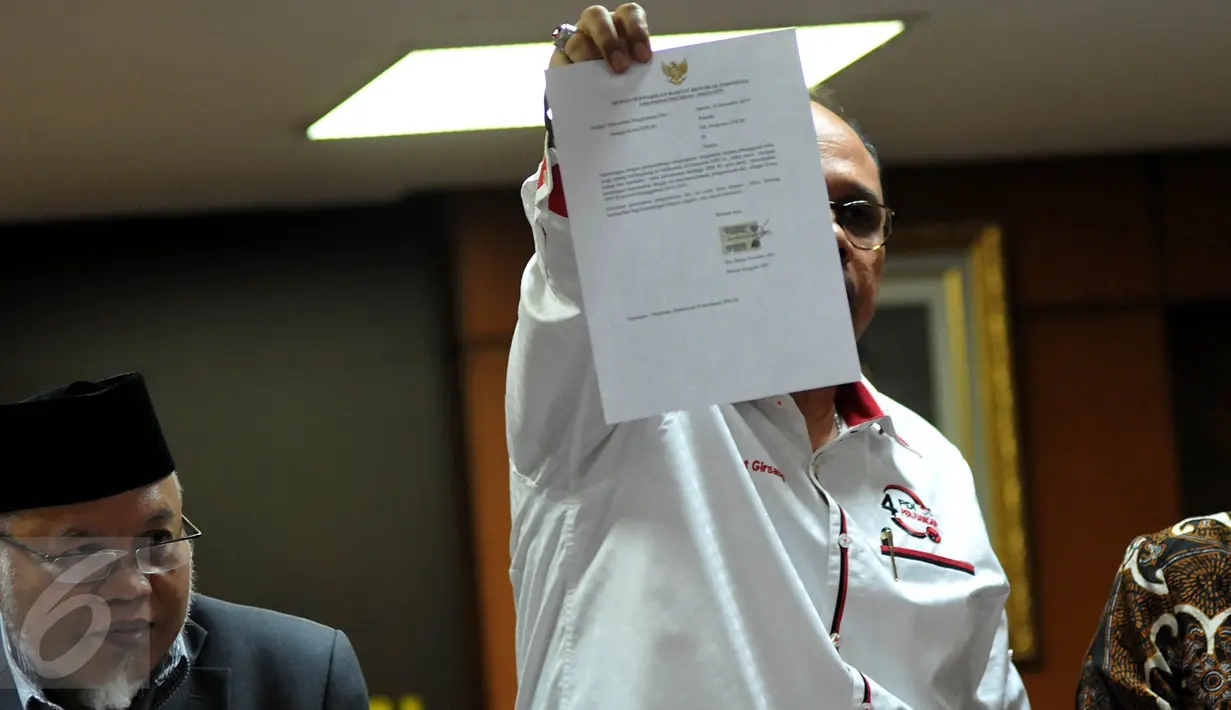 Wakil Ketua Junimart Girsang menunjukan surat pengunguran diri Setya Novanto dari Ketua DPR, Jakarta, Rabu (16/12/2015). Dengan adanya surat tersebut maka masa sidang Pelanggaran Etik Setya Novanto dinyatakan selesai. (Liputan6.com/Johan Tallo)