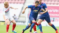 Pemain baru MU, Henrikh Mkhitaryan, berusaha melewati pemain Wigan Athletic dalam laga persahabatan di Stadion DW, Wigan, (16/7/2016). (Bola.com/Twitter/ManUtd)