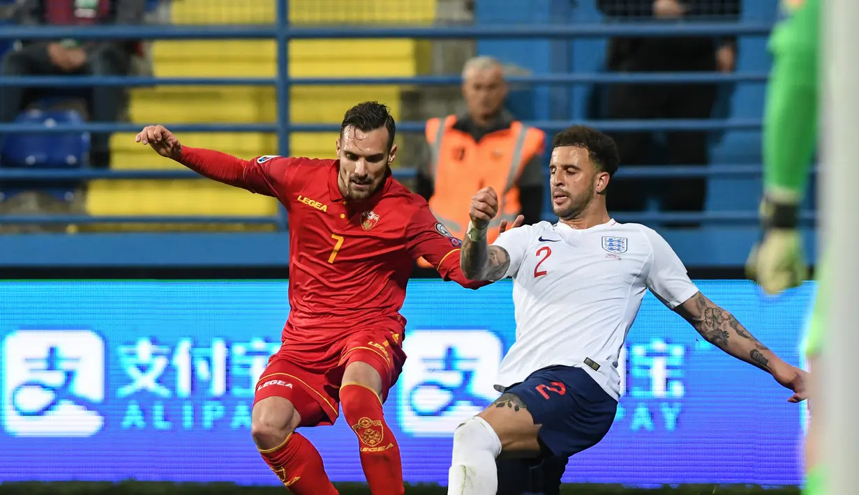 Marko Vesovic mencoba melewati pemain Inggris, Kyle Walker pada laga kedua Kualifikasi Piala Eropa 2020 yang berlangsung di Stadion Pod Goricom, Podgrica, Selasa (26/3). Timnas Inggris menang 5-1 atas Montenegro. (AFP/Savo Prelevic)