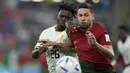 Bek Ghana Alidu Seidu  berebut bola dengan bek Portugal Raphael Guerreiro pada duel grup H Piala Dunia 2022 di stadion 974, Kamis (24/11/2022).  Portugal berhasil memimpin klasemen grup H usai kemenangan 3-2 atas Ghana.  (AP Photo/Darko Bandic)