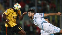 Striker Belgia, Michy Batshuayi, duel udara dengan bek San Marino, Mirko Palazzi, pada laga Kualifikasi Piala Dunia 2022 di Olympic Stadium, Serravalle, Jumat (6/9). San Marino kalah 0-4 dari Belgia. (AFP/Isabella Bonotto)