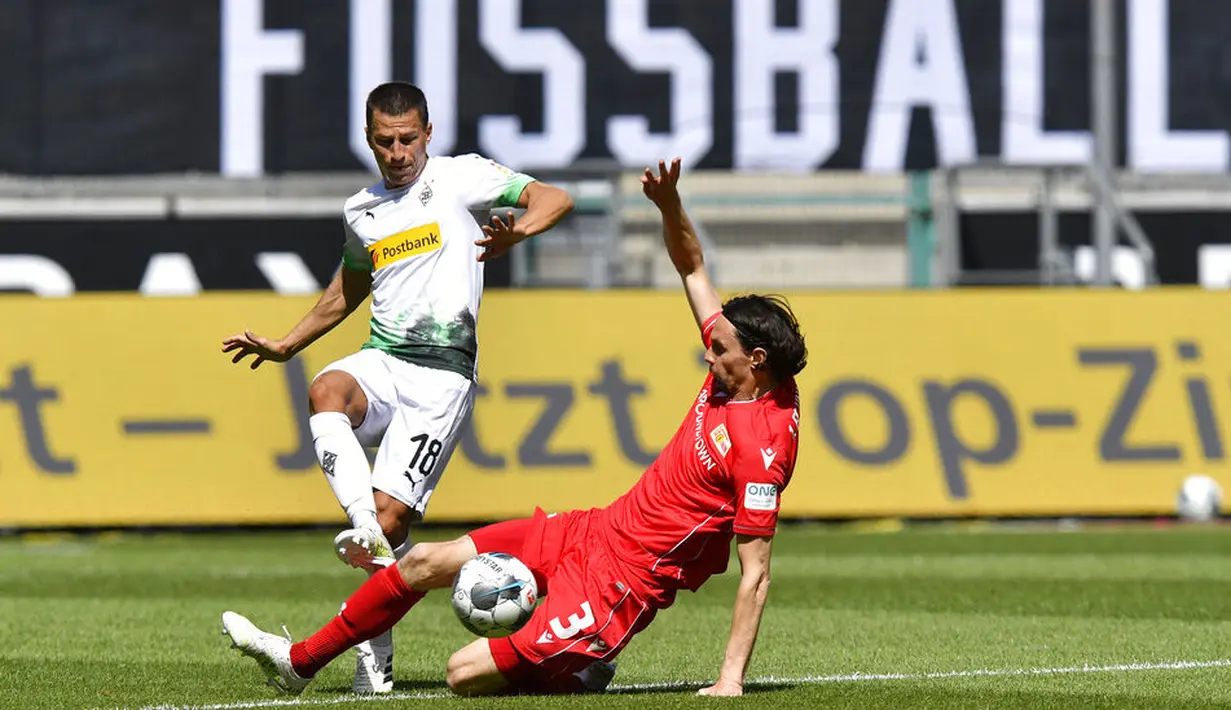 Pemain Borussia Moenchengladbach, Stefan Lainer, berebut bola dengan pemain Union Berlin, Neven Subotic, pada laga Bundesliga di Stadion Borussia-Park, Minggu (31/5/2020). Moenchengladbach menang 4-1 atas Union Berlin. (AP/Martin Meissner)