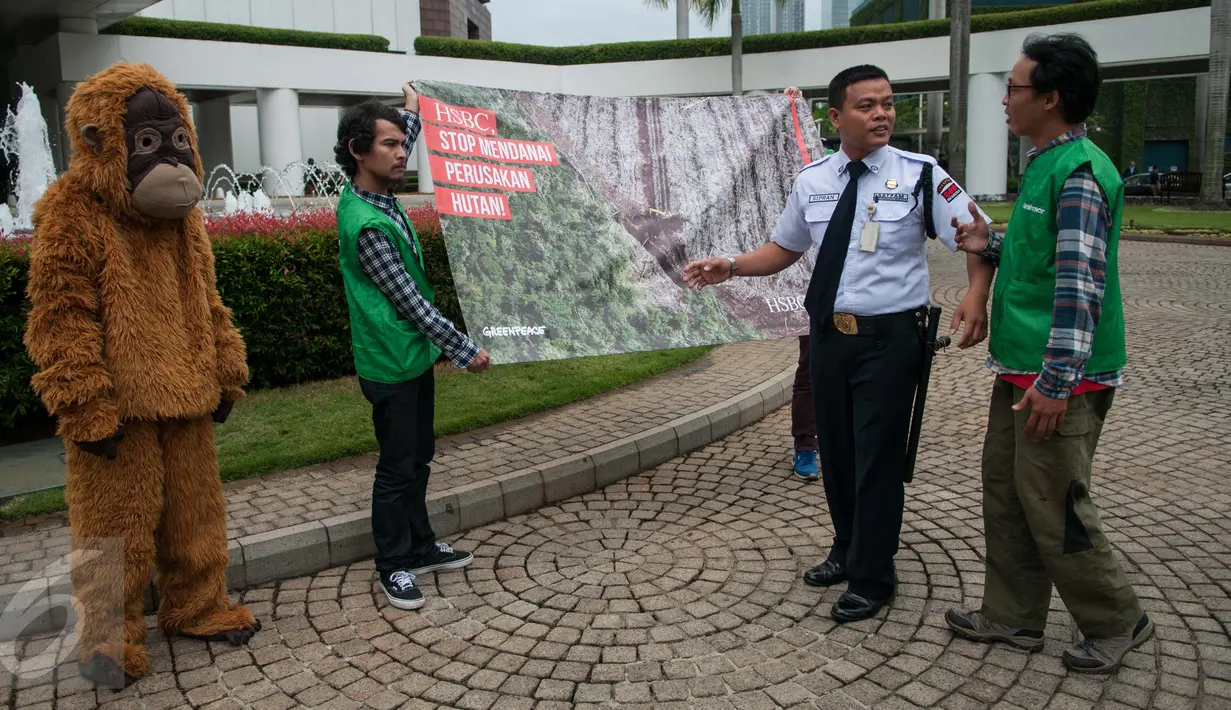 Petugas keamanan menghalau aktivis Greenpeace Indonesia, pewakilan Tim Cegah Api, dan Orangutan melakukan teatrikal saat aksi damai di kawasan kantor HSBC, kompleks World Trade Center (WTC) I, Jakarta, Kamis (9/2). (Liputan6.com/Gempur M Surya)