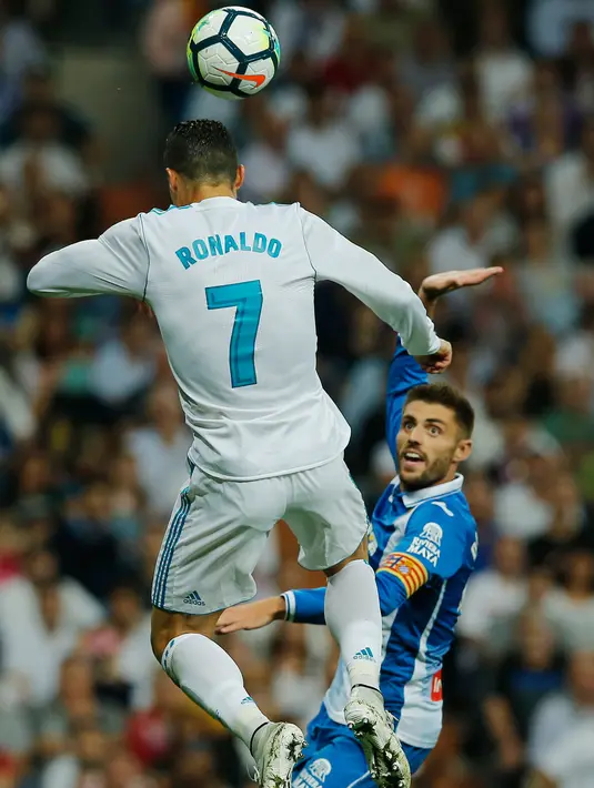 Pemain Real Madrid, Cristiano Ronaldo mrelompat untuk melakukan sundulan dalam lanjutan La Liga 2017/2018 melawan Espanyol di Santiago Bernabeu, Minggu (1/10). Real Madrid sukses menundukkan Espanyol dua gol tanpa balas. (AP/Paul White)