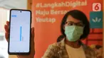 Model menunjukkan grafik cash flow pada aplikasi Youtap di coffe shop, Gading Serpong, Tangsel, Sabtu (14/11/2020). Youtap mendorong penggunaan pembayaran non-tunai kepada pelaku usaha demi memberi transaksi yang lebih higienis di tengah pandemi Covid-19. (Liputan6.com/Fery Pradolo)