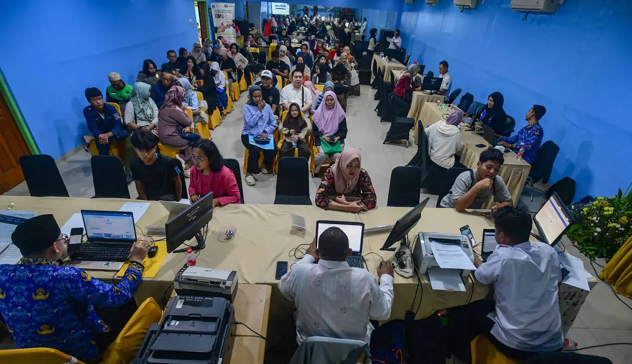 Petugas melayani orang tua calon siswa yang mencari informasi mengenai Sistem Penerimaan Murid Baru (SPMB) Tahun Ajaran 2026/2027 di Posko Pelayanan SPMB Suku Dinas Pendidikan Wilayah III yang berada di SMAN 70 Jakarta, Rabu (17/6/2026). (merdeka.com/Arie Basuki)