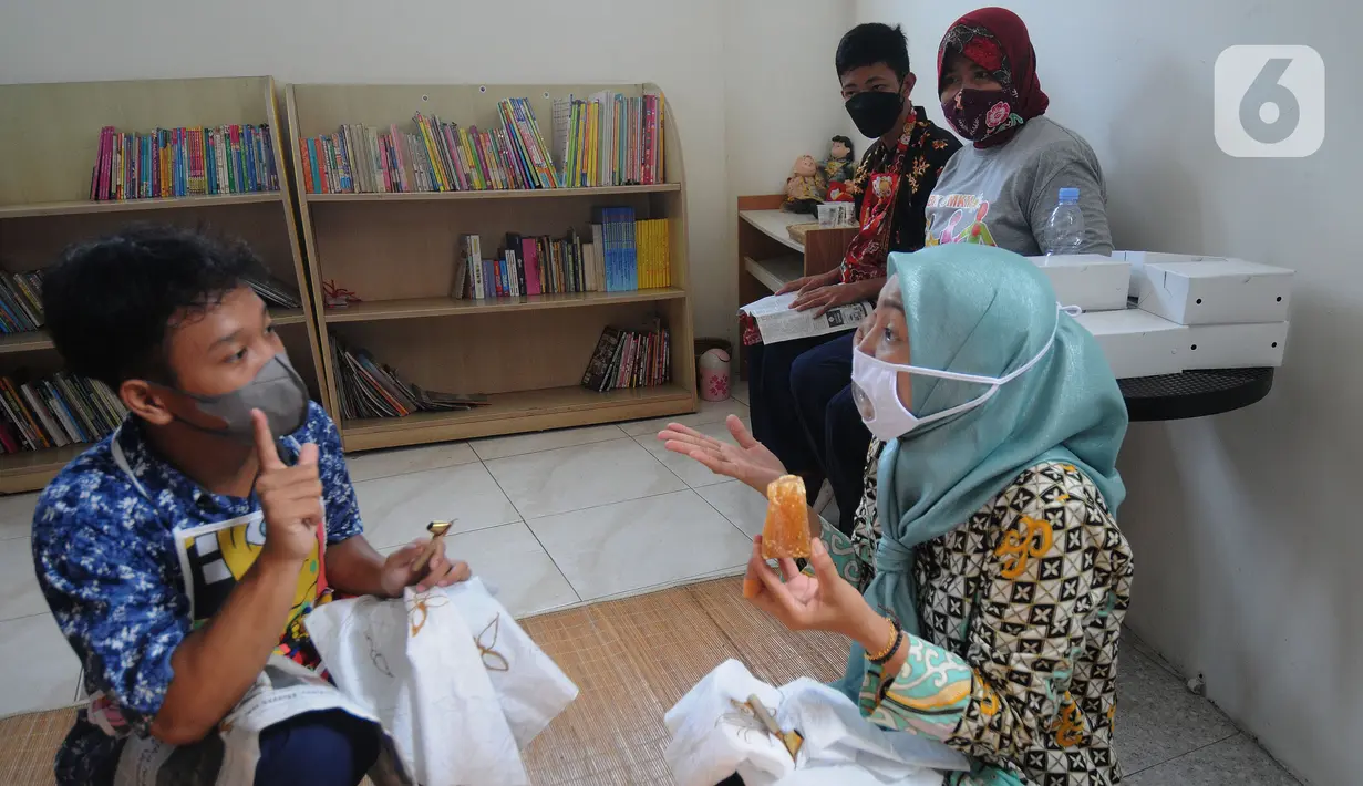 Anak berkebutuhan khusus (ABK) penyandang tunarungu belajar membatik yang diselenggarakan oleh Yayasan Griya Bina Karya di gerai ABK UMKM di Pasar Gintung, Ciputat, Tangsel, Minggu (2/10/2021). Kegiatan ini dalam rangka memperingati Hari batik Nasional 2 Oktober. (merdeka.com/Arie Basuki)