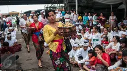 Umat Hindu membawa sesajen pada prosesi Tawur Agung Kesanga sehari menjelang Hari Raya Nyepi di Pura Aditya Jaya, Jakarta, Senin (27/3). Kegiatan Tawur Agung Kesanga merupakan salah satu dari empat ritual utama perayaan Nyepi (Liputan6.com/Gempur M Surya)