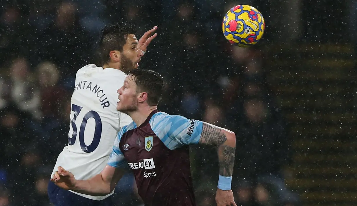 Gelandang Tottenham Hotspur, Rodrigo Bentancur (kiri) berebut bola dengan penyerang Burnley, Wout Weghorst selama pertandingan lanjutan Liga Inggris di Stadion Turf Moor, Inggris, Kamis (24/2/2022). Burnley menang tipis atas Tottenham 1-0. (AFP/Nigel Roddis)