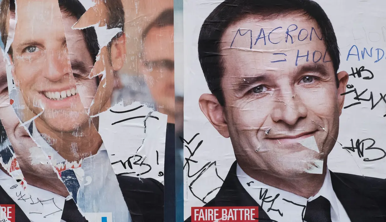 Poster Capres Prancis,  Marine Le Pen terlihat rusak di Paris, Selasa (2/5). Sejumlah poster capres Prancis lainnya juga tampak rusak yang diduga dilakukan oleh orang yang tidak suka dengan mereka. (AFP PHOTO / JOEL SAGET)