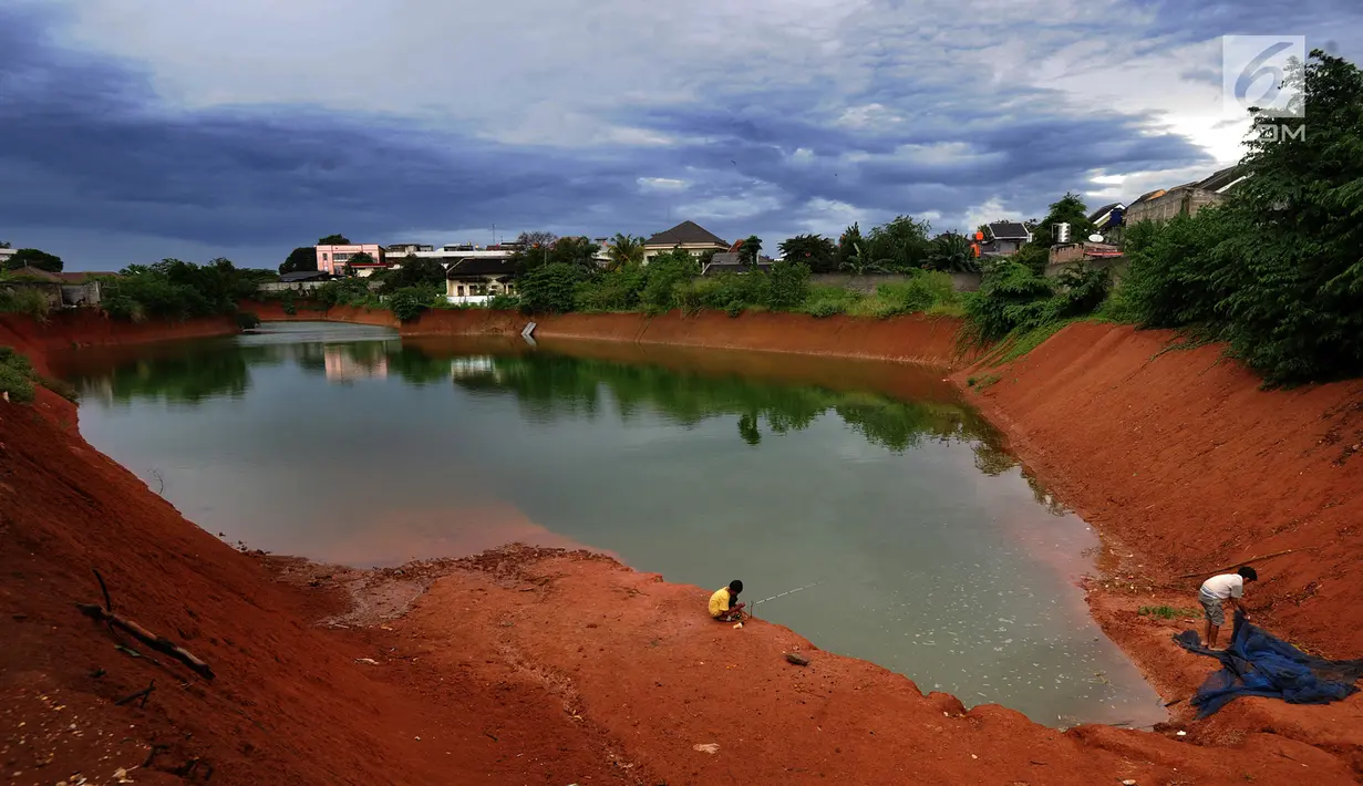 Anak-anak memancing pada bagian proyek pembangunan tol Cinere-Serpong yang berubah menjadi danau sedalam 4 meter di kawasan Cipayung, Tangsel, Banten (17/1). (Merdeka.com/Arie Basuki)