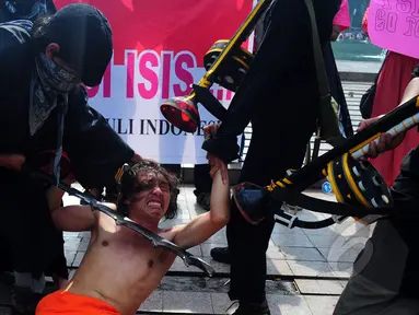 Sejumlah mahasiswa melakukan aksi menolak ISIS di Car Free Day, Bundaran HI, Jakarta, Minggu (15/3/2015). Mereka melakukan aksi teaterikal sebagai bentuk sindiran terhadap kekejaman ISIS. (Liputan6.com/Yoppy Renato) 