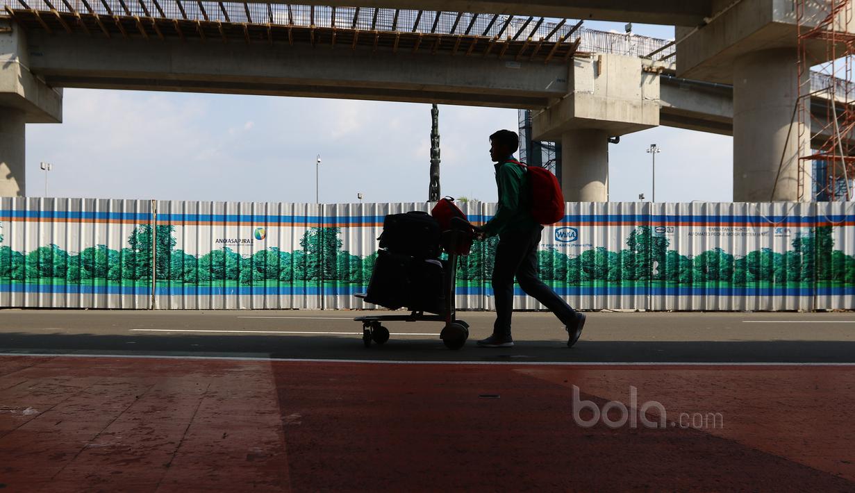 Pemain Timnas Indonesia U-16, Brylian Negietha mendorong kereta bawang menuju bus saat tiba di Bandara Soekarno-Hatta, Cengkareng, Senin (19/6/2017). Timnas U-16 meraih juara pada ajang Tien Phong Plastic Tournament 2017. (Bola.com/Nicklas Hanoatubun)