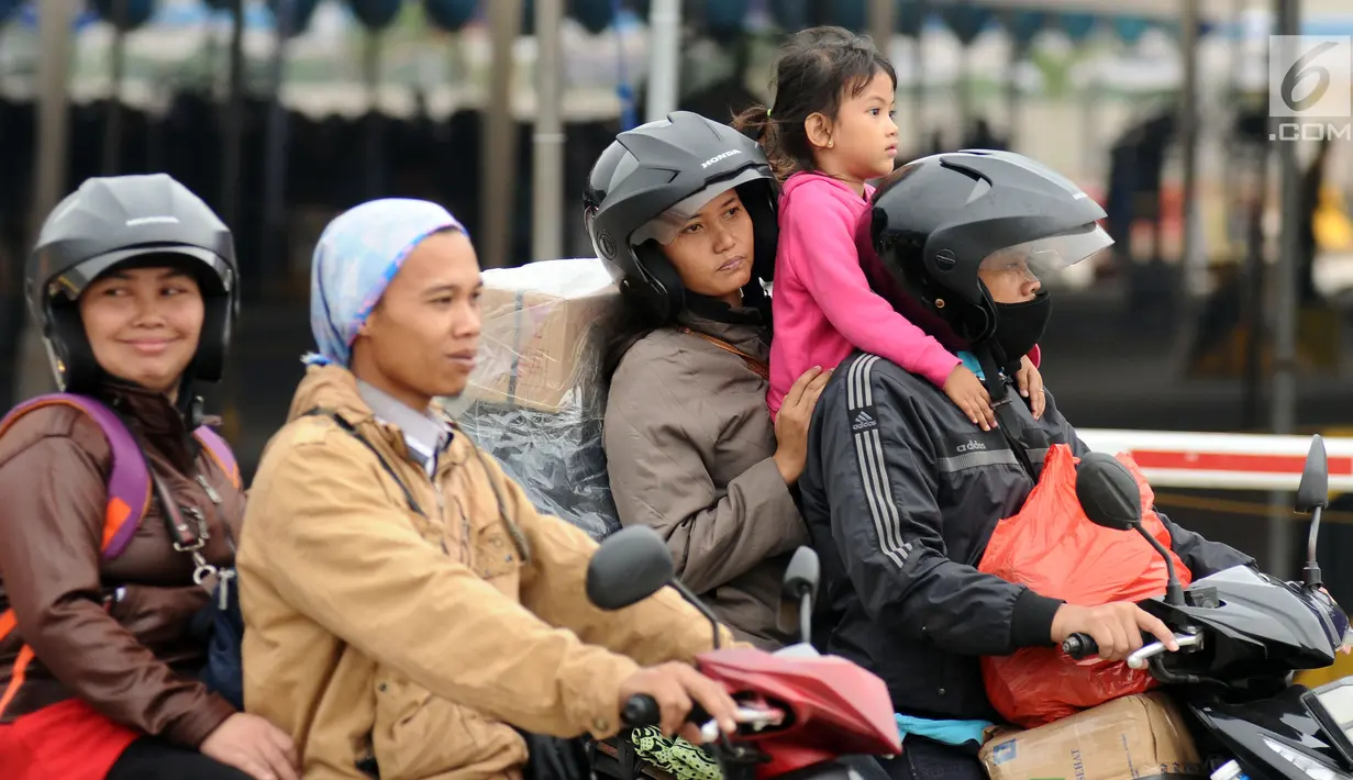 Pemudik membawa anaknya saat akan memasuki kapal penyereberangan di Dermaga 6 Pelabuhan Merak, Banten, Kamis (22/6). Meski sudah dihimbau oleh pihak berwenang, namun masih banyak pemudik bermotor yang membawa anak. (Liputan6.com/Helmi Fithriansyah)