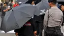 Seorang petugas saat menjaga aksi Kamisan ke-378 di seberang Istana Negara, Jakarta, Kamis (11/12/2014). (Liputan6.com/Miftahul Hayat)