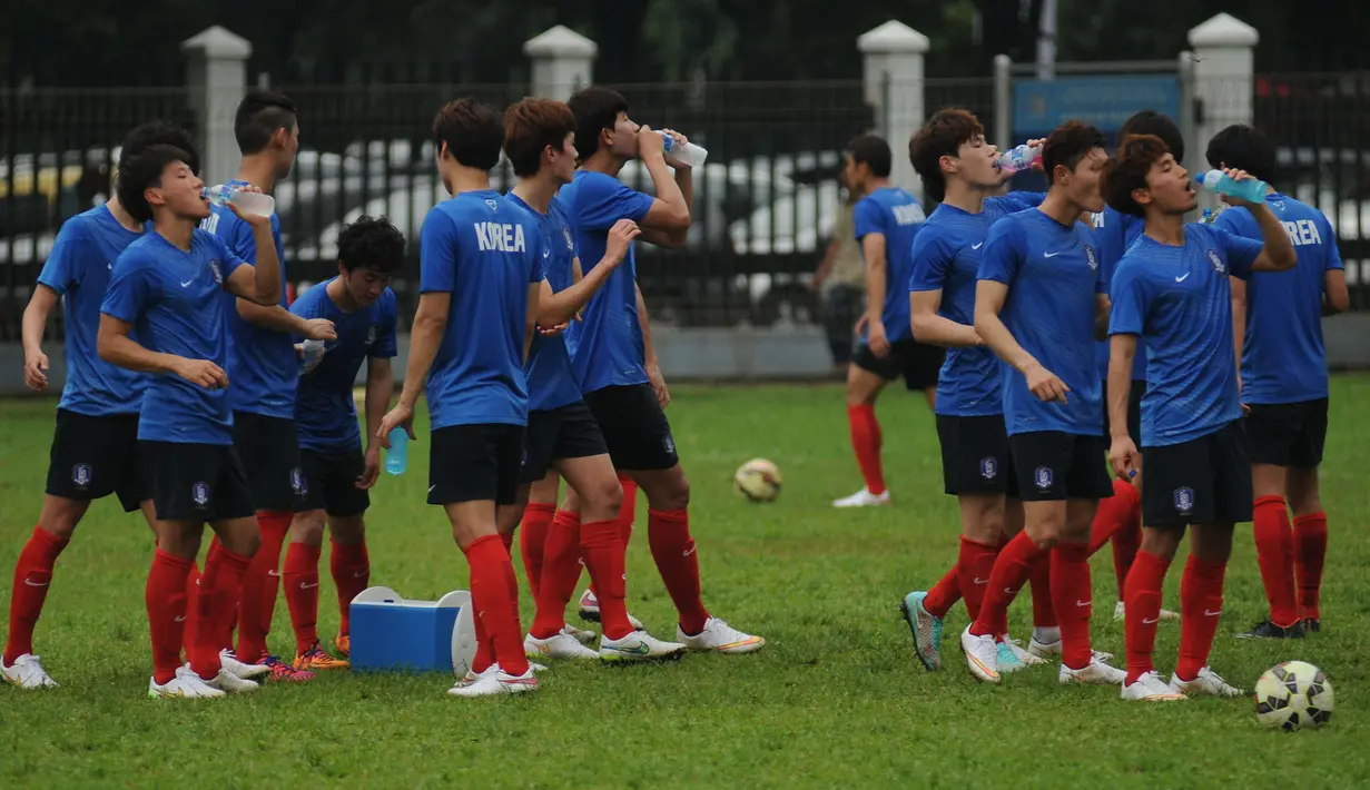 Sejumlah pemain timnas Korea Selatan U-23 beristirahat sambil meminum air di sela sela latihan pedana jelang laga  kualifikasi Grup H Piala Asia 2016 di Lapangan C Senayan, Jakarta, (21/3/2015). (Liputan6.com/Helmi Fithriansyah)