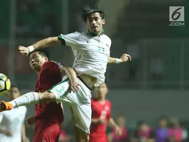Pemain belakang Indonesia U-23, Gavin Kwan Adsit (kanan) berebut bola dengan pemain Korea Utara pada laga PSSI Anniversary Cup 2018 di Stadion Pakansari, Kab Bogor, Senin (30/4). Laga kedua tim berakhir imbang 0-0. (Liputan6.com/Helmi Fithriansyah)