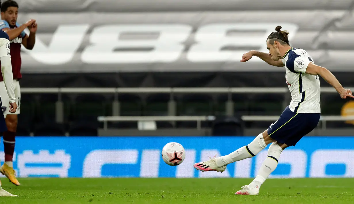 Striker Tottenham Hotspur, Gareth Bale (kanan) melakukan tendangan bebas saat pertandingan Liga Inggris menghadapi West Ham di Tottenham Hotspur Stadium, Minggu (18/10/2020). Laga yang berakhir dramatis 3-3 itu diwarnai debut bintang anyar Tottenham, Gareth Bale. (Matt Dunham/POOL/AFP)