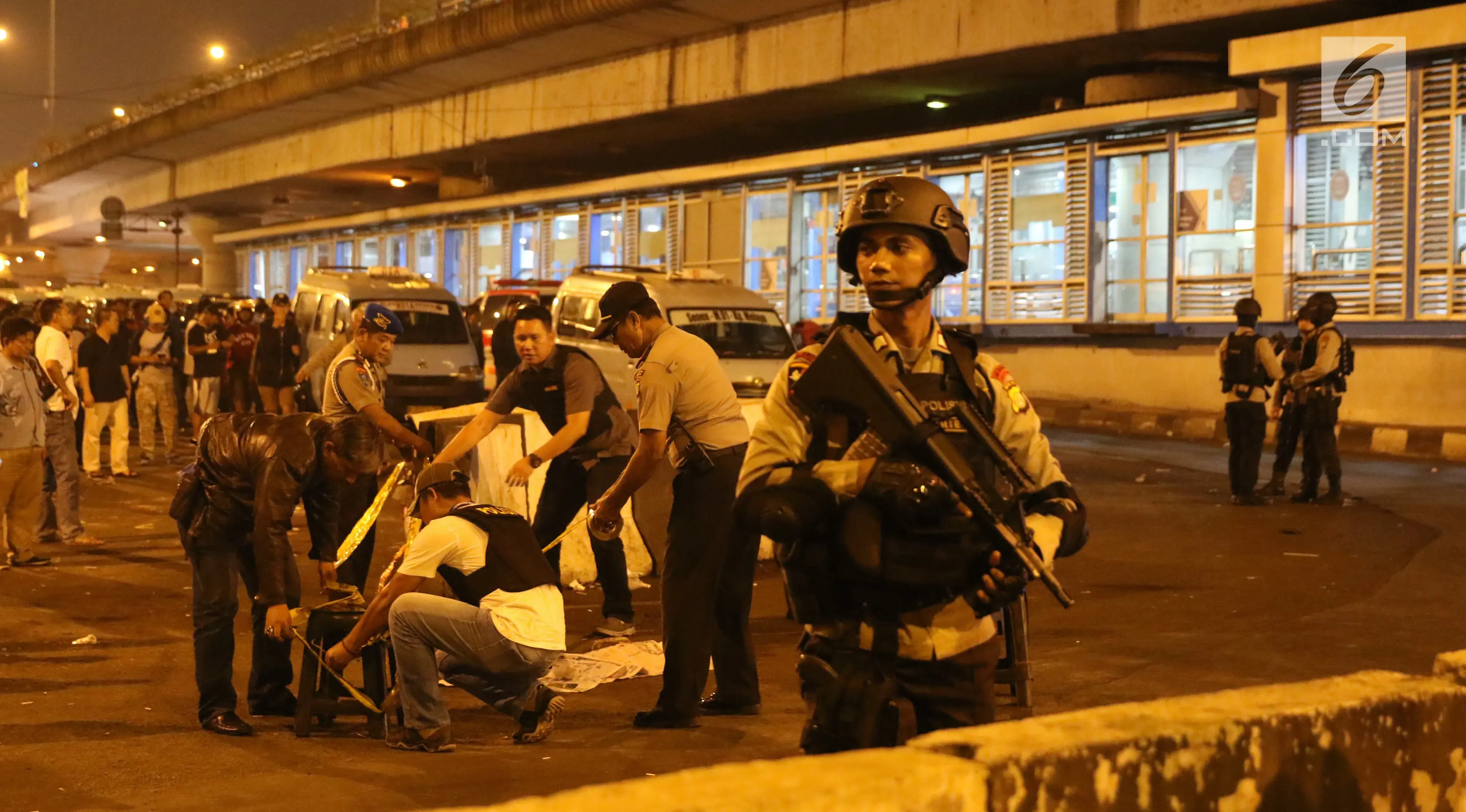 Sejumlah polisi berjaga di sekitar Terminal Kampung Melayu, Jakarta, Rabu (24/5). Polisi dari Polres Jakarta Timur dan Gegana Polda Metro Jaya tengah menyusuri lokasi ledakan. (Liputan6.com/Angga Yuniar)