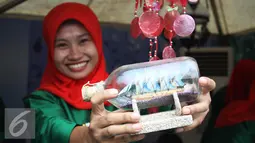 Seorang penjaga stan memperlihatkan barang dagangannya di acara palang pintu Lebaran Betawi di Lapangan Banteng, Jakarta (22/08/15). Acara ini akan berlangsung pada tanggal 22-23 Agustus. (Liputan6.com/Gempur M Surya)