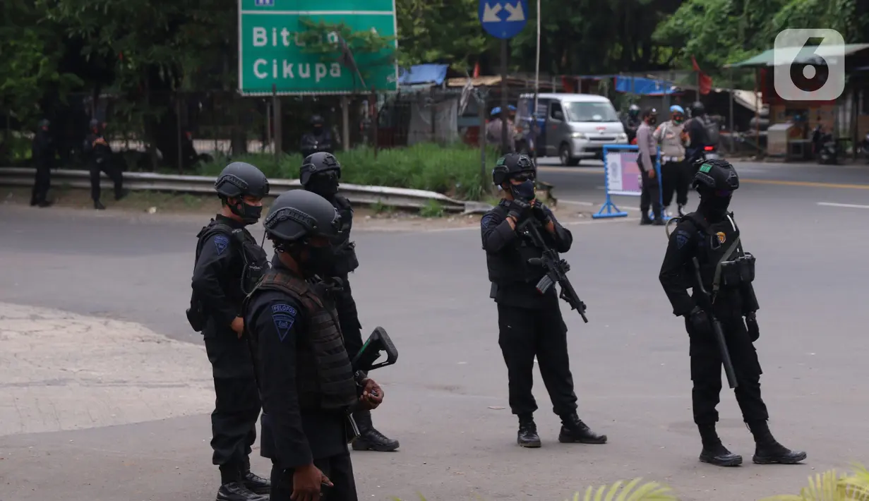 Personel Brimob bersenjata melakukan penjagaan ketat di depan pintu masuk Tol Bitung, Tangerang, Baten, Selasa (6/10/2020). Penjagan ketat dilakukan untuk mengamankan dan mencegah aksi buruh yang akan menggelar aksi menolak UU Cipta Kerja. (Liputan6.com/Angga Yuniar)