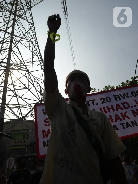 Warga mengepalkan tangan saat petugas gabungan melakukan eksekusi lahan rumah warga Kelurahan Pulogebang RT 20 RW 06 (dahulu RT 08/RW 06) di Jakarta, Selasa (8/6/2021). Eksekusi lahan tersebut berakhir ricuh. (merdeka.com/Imam Buhori)