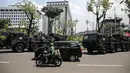 Pengendara melintas saat sejumlah kendaraan alat utama sistem senjata (alutsista) TNI berjajar di kawasan Istana Merdeka, Jakarta, Selasa (4/10/2022). Kegiatan ini dalam rangka HUT ke-77 TNI yang akan berlangsung di Istana Merdeka pada 5 Oktober besok. (Liputan6.com/Faizal Fanani)