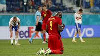 Romelu Lukaku berlutut di lapangan pada akhir pertandingan grup B kejuaraan sepak bola EURO 2020 antara Belgia dan Rusia di Stadion Krestovsky, Saint Petersburg (13/06/2021) dini hari WIB. (AP/Pool/Anatoly Maltsev)