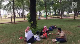 Pengunjung bercengkerama di sekitar Taman Monas, Jakarta, Rabu (17/1). Gubernur Anies Baswedan melalui Kepala Unit Pengelola Kawasan (UPK) Monas mencabut larangan menginjak rumput di kawasan tersebut. (Liputan6.com/Immanuel Antonius)