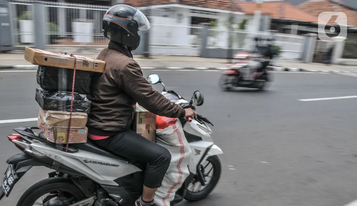 Kurir saat mengantarkan paket konsumen e-Commerce dengan sepeda motor di Jakarta, Kamis (23/9/2021). Kenaikan di sepanjang semester I/2020 secara tahunan dengan total nilai transaksi mencapai Rp186,75 triliun. (merdeka.com/Iqbal S. Nugroho)