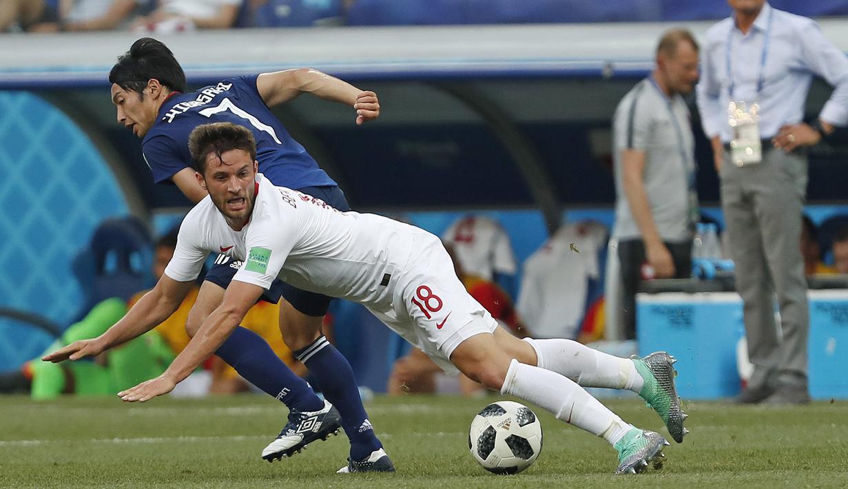 Pemain Polandia, Bartosz Bereszynski (depan) jatuh saat berebut bola dengan pemain Jepang, Gaku Shibasaki pada laga terakhir grup H di Volgograd Arena, Volgograd, Rusia (28/6/2018). Jepang kalah 0-1 dari Polandia. (AP/Darko Vojinovic)