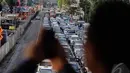 Salah seorang pejalan kaki saat mengabadikan kemacetan di Jl MH Thamrin, Jakarta, Kamis (18/12/2014). (Liputan6.com/Faizal Fanani)