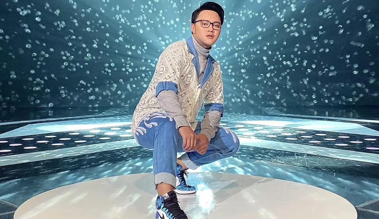 Pria kelahiran 1991 ini teryata kerap tampil sporty di berbagai momen. Saat mengisi acara di televisi, ia tampil keren dengan gaya sporty. Danang D'Academy tampak keren dengan sneakers berwarna biru senada dengan busananya.(Liputan6.com/IG/@danang_official91)