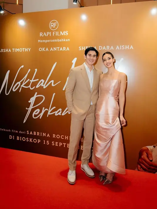Mengenakan setelan jas dan celana panjang warna pinggala dipadukan dengan kemeja berikut sepatu putih, Vino G Bastian melangkah ke karpet merah menemani istri. Bintang film Miracle In Cell No. 7 tampil gaya bersama rancangan Wong Hang Tailor. Sementara Marsha Timothy memesona dengan gaun panjang tanpa lengan warna bangbang mengilap. (Foto: Dok. Instagram @vinogbastian__)