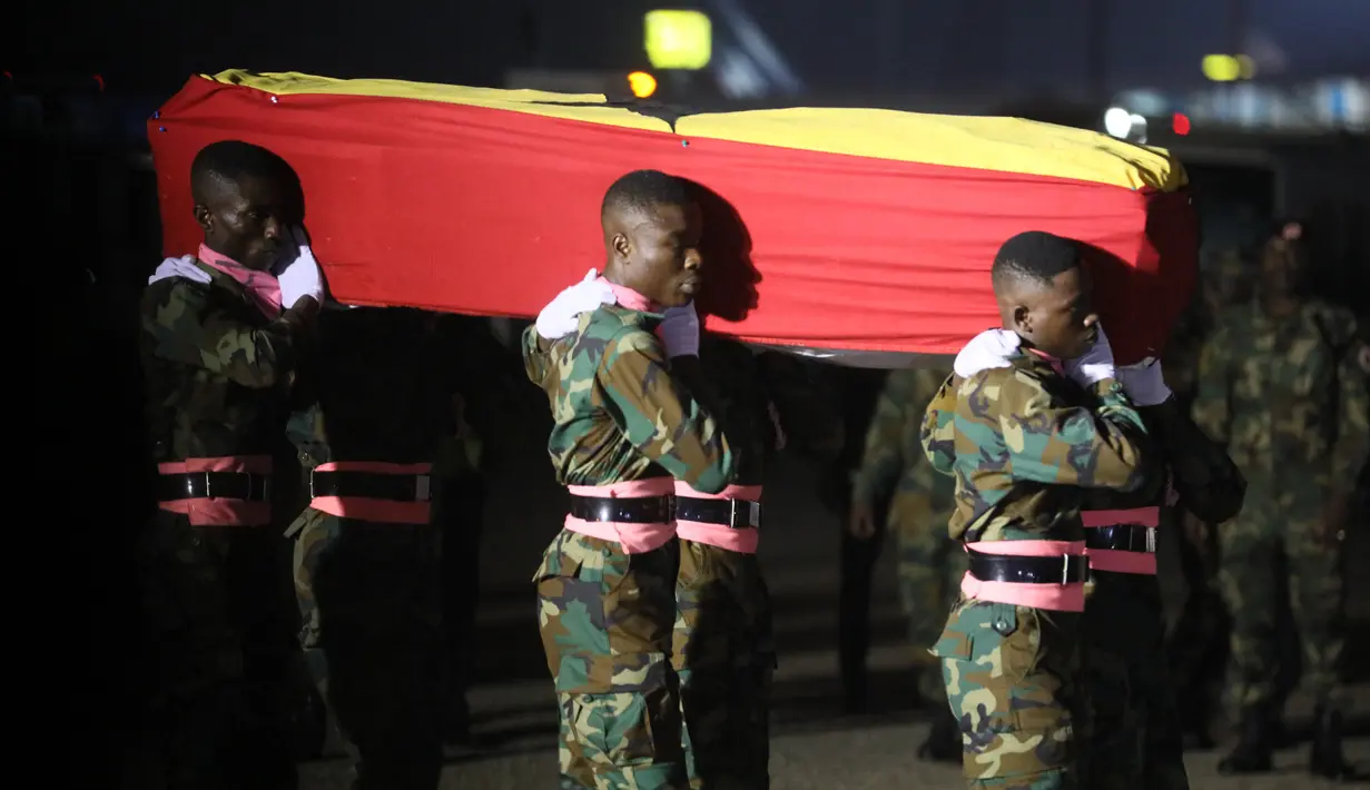 Petugas membawa peti mati berisi jenazah pesepakbola asal Ghana Christian Atsu saat tiba di Bandara Internasional Kotoka di Accra, Ghana, Minggu (19/2/2023). Atsu (31) menjadi salah satu korban gempa berkekuatan magnitudo 7,8 yang mengguncang Turki dan Suriah pada 6 Februari, menewaskan lebih dari 44.000 orang di kedua negara tersebut. (Photo by Nipah Dennis / AFP)