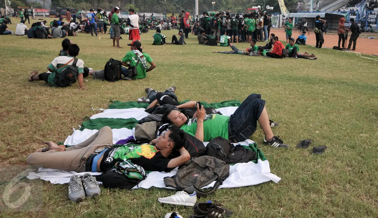 Pendukung  Persebaya Surabaya (Bonek) tampak bersantai di Stadion Tugu, Koja, Jakarta Utara, Selasa (2/8). Bonek meminta kepada federasi sepakbola Indonesia itu untuk mengembalikan hak-hak Persebaya.(Liputan6.com/Yoppy Renato)