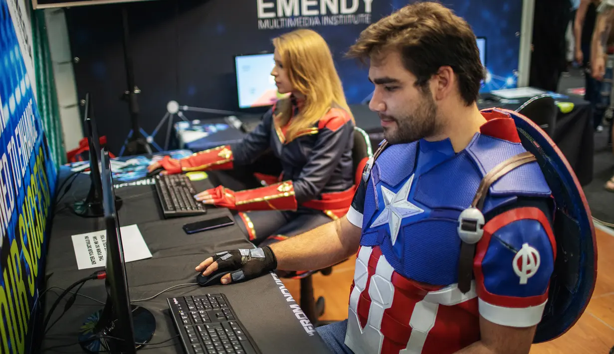 Cosplayer berkostum ala karakter Captain America dan Captain Marvel bermain video game dalam acara Comic Con Africa di Johannesburg, Sabtu (21/9/2019). Comic Con Africa untuk tahun kedua di benua itu  akan berlangsung selama empat hari dari 21 hingga 24 September. (Michele Spatari/AFP)