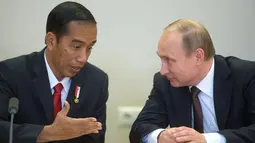 Presiden RI, Jokowi dan Presiden Rusia, Vladimir Putin (kanan) berbincang disela upacara penandatanganan seusai pertemuan di Sochi, Rusia, Rabu (18/5). Kedua pemimpin negara itu melakukan pertemuan bilateral sebelum KTT ASEAN-Rusia (Host Photo Agency/AFP)