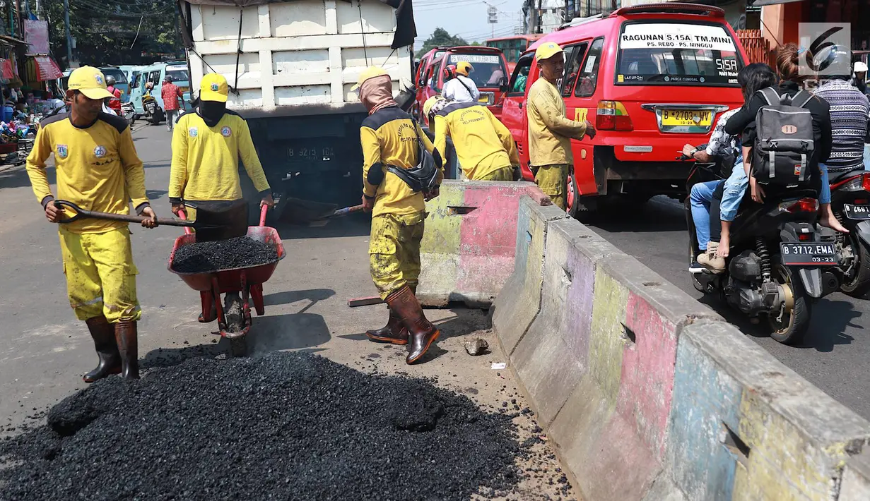 Petugas Bina Marga Pasar Minggu menambal jalan yang rusak di Jalan Raya Ragunan, Jakarta, Senin (22/4). Petugas mengaku bahwa keberadaan beton pembatas jalan justru membuat jalan di kawasan tersebut selalu rusak setiap hujan deras karena menimbulkan genangan air. (Liputan6.com/Immanuel Antonius)