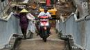 Pengendara motor melintas di samping pejalan kaki menaiki Jembatan Penyeberangan Orang kawasan Cikunir, Bekasi Barat, Senin (12/3). JPO yang diperuntukkan bagi pejalan kaki ini justru digunakan pemotor mencari jalan pintas. (Liputan6.com/Arya Manggala)