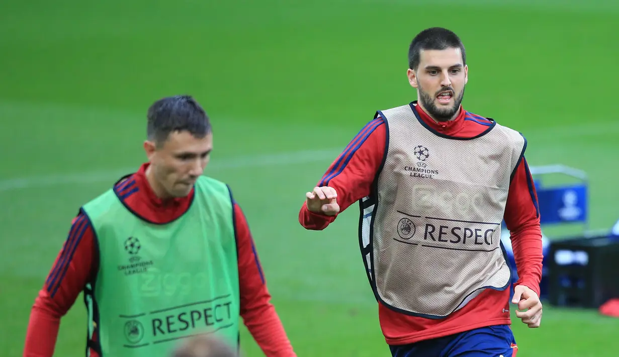 <p>Gelandang Ajax Florian Grillitsch (kanan) mengambil bagian dalam sesi latihan di Stadion Anfield di Liverpool, 12 September 2022. Diketahui pelaksanaan Liga Champions 2022/2023 akan tetap digelar, meski seluruh klub dari Liga Inggris tengah berkabung atas wafatnya Ratu Elizabeth II. (Lindsey Parnaby / AFP)</p>