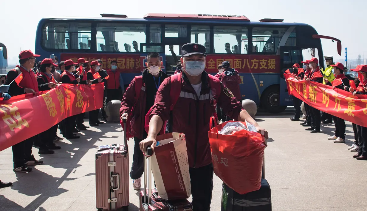 Sejumlah staf medis dari Provinsi Guizhou berjalan untuk menaiki kereta di Stasiun Kereta Api Wuhan di Provinsi Hubei, China (17/3/2020). Beberapa tim bantuan medis mulai meninggalkan Provinsi Hubei ketika epidemi COVID-19 yang terkena dampak paling parah itu terus menurun. (Xinhua/Xiao Yijiu)