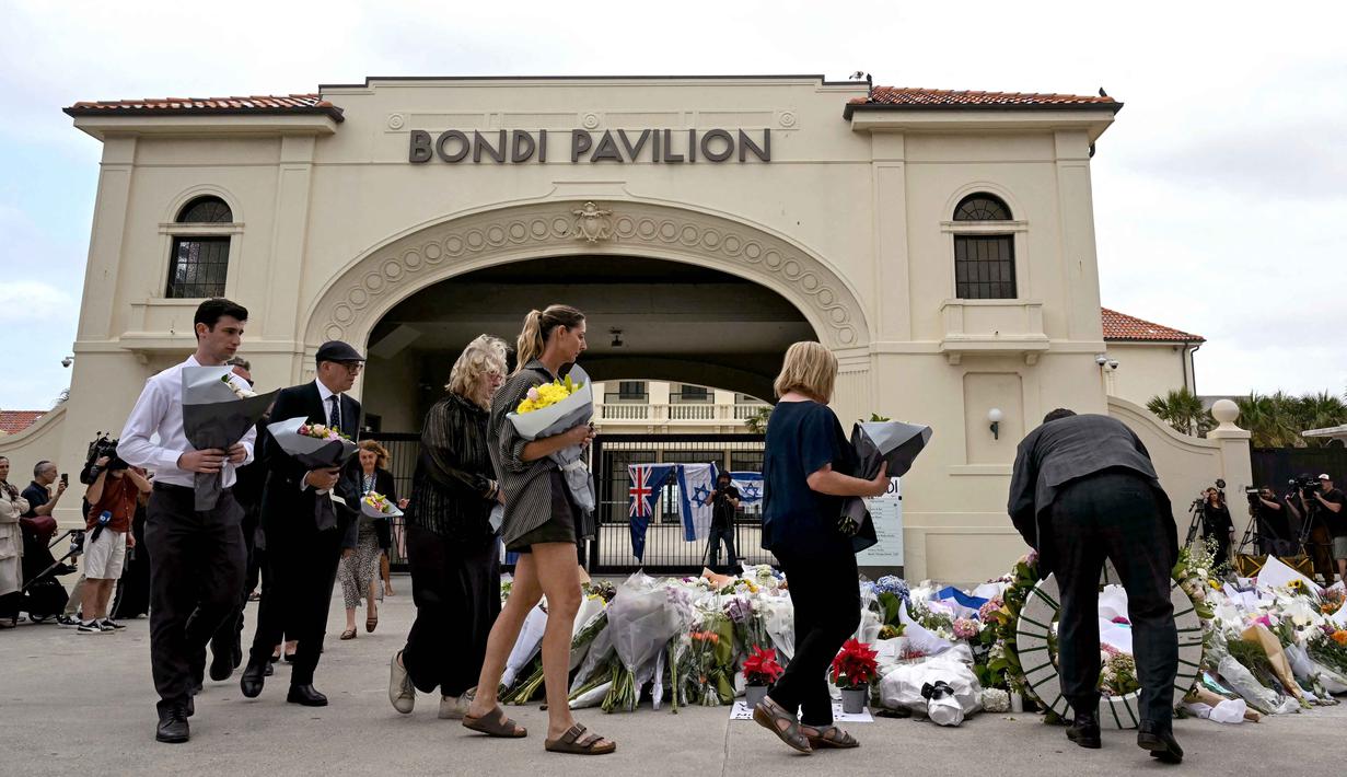 Berdasar hasil penggeledahan, pelaku memiliki sedikitnya enam senjata api yang seluruhnya terdaftar dan mengantongi izin resmi. Senjata yang digunakan dalam serangan tersebut diduga mencakup senapan dan senapan laras panjang. Tampak dalam foto, para pelayat memberikan penghormatan terakhir dengan meletakkan karangan bunga untuk para korban penembakan Pantai Bondi di Bondi Pavilion, Sydney, Australia pada Senin 15 Desember 2025. (Saeed KHAN/AFP)