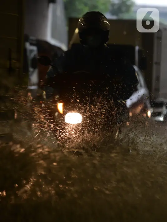 Pengendara sepeda motor menerjang banjir yang merendam terowongan di Cawang, Jakarta, Jumat (19/2/2021). Hujan yang turun sejak semalam membuat sejumlah jalanan di Ibu Kota tergenang banjir dengan ketinggian sekitar 30-50 cm. (merdeka.com/Imam Buhori)