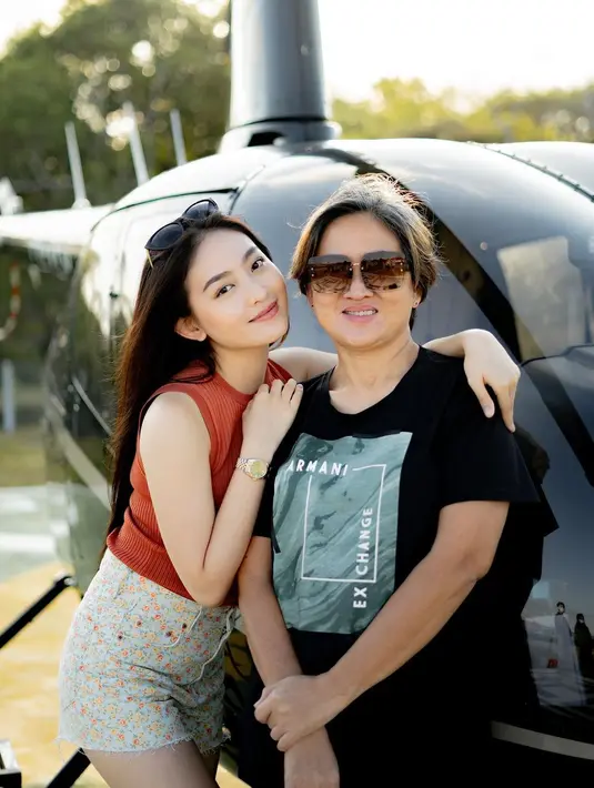 Natasha Wilona mengajak ibunya naik helikopter. Sebelum naik, keduanya berpose dengan latar pesawat terbang tersebut. (Foto: Instagram/@natashawilona12)