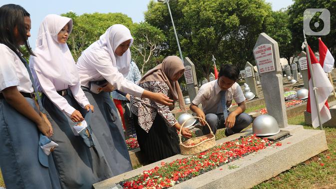 Sejumlah pelajar melakukan tabur bunga saat peringatan Hari Pahlawan Nasional di Taman Makam Pahlawan (TMP) Utama Kalibata, Jakarta Selatan, Minggu (10/11/2109). Ziarah tersebut digelar dalam rangka peringatan Hari Pahlawan 10 November 2019. (Liputan6.com/Herman Zakharia)
