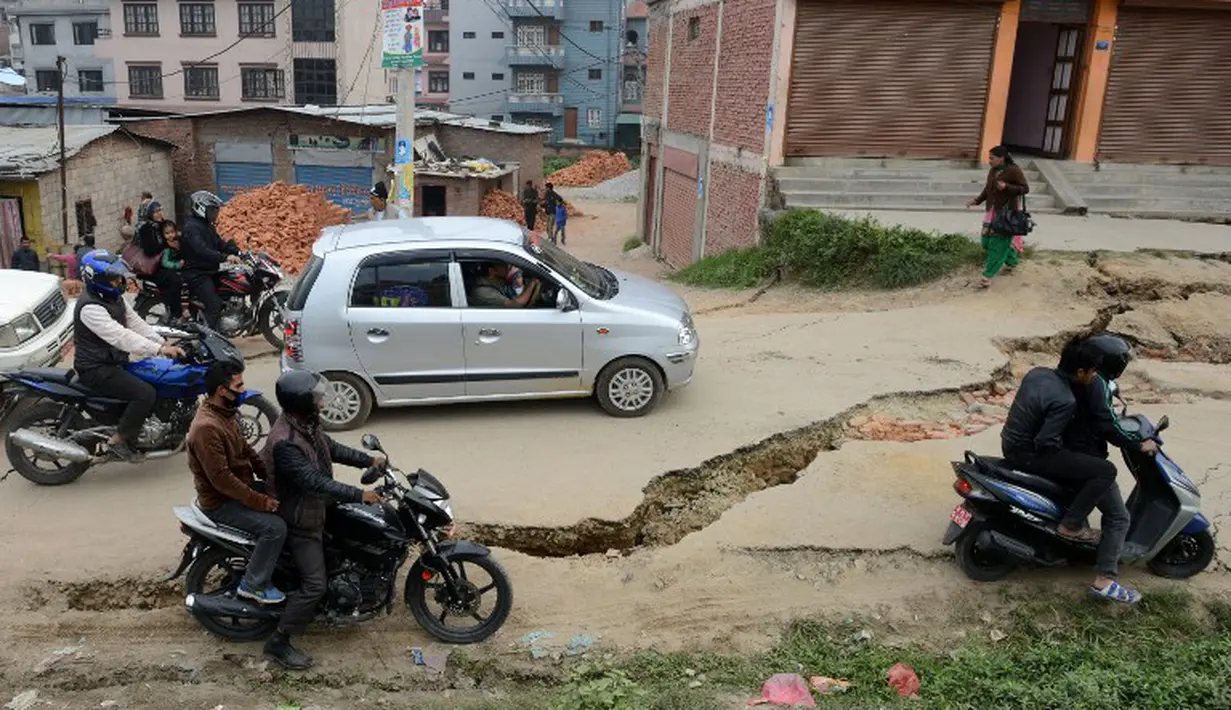 Jalan yang rusak mengakibatkan arus lalu lintas menjadi tersendat, Minggu (26/4/2015). Gempa berkekuatan 7,8 Skala Richter dikabarkan telah menelan korban sekitar 2000 jiwa. (AFP Photo/Prakash Mathema)